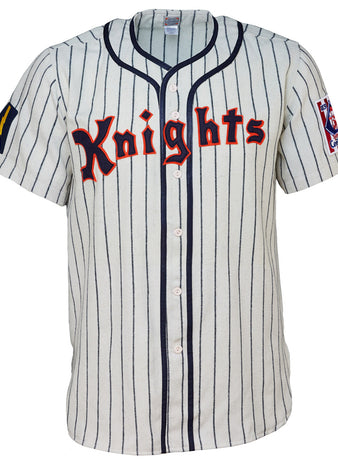 The EFF New York Knights 1939 Home Jersey features white fabric, vertical navy stripes, red Knights lettering, and sleeve patches—ideal for a Roy Hobbs costume or any fan of The Natural.
