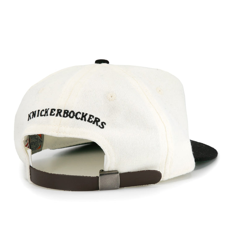 The EFF New York Knickerbockers Vintage Inspired Ballcap features a white crown, black brim, “KNICKERBOCKERS” embroidered in black, and an adjustable brown strap for a classic look.