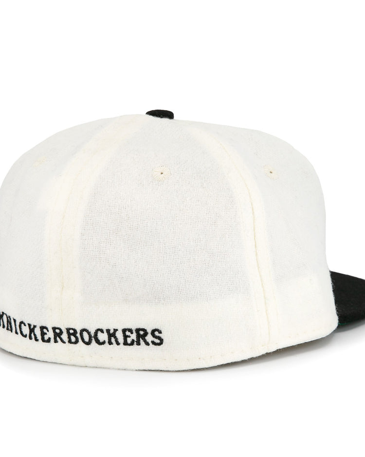 The EFF New York Knickerbockers Vintage Inspired Ballcap features a white crown, black brim, and KNICKERBOCKERS embroidered in black above the adjustable band for classic NYC style.