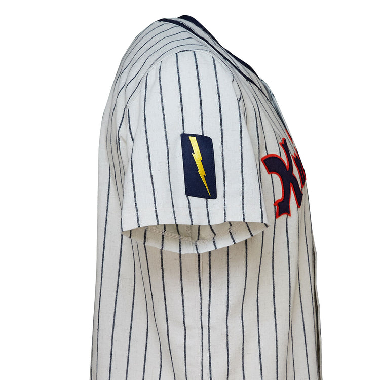 A close-up of the EFF New York Knights 1939 Home Jersey, a white pinstriped short-sleeve baseball jersey with a red chest logo and yellow lightning bolt patch on the left sleeve, inspired by The Natural.