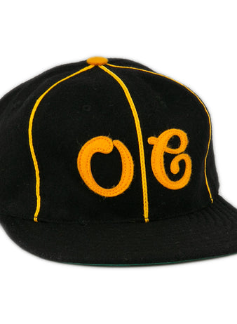 The EFF Oakland Caskets Co. 1938 Vintage Ballcap is a black cap with yellow piping, bold OC front stitching, a yellow top button, and flat brim. Made in the USA for classic style and quality.