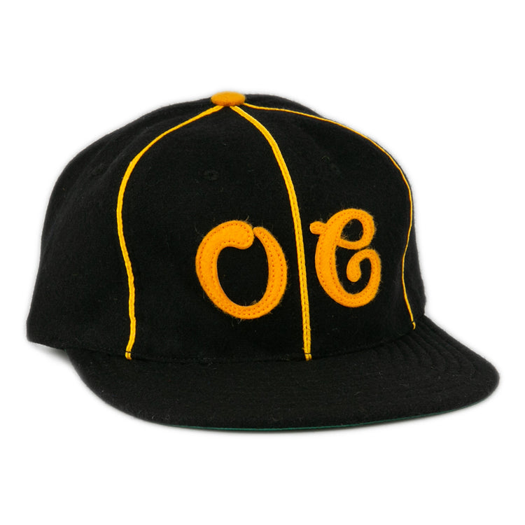 The EFF Oakland Caskets Co. 1938 Vintage Ballcap is a black cap with yellow piping, bold OC front stitching, a yellow top button, and flat brim. Made in the USA for classic style and quality.
