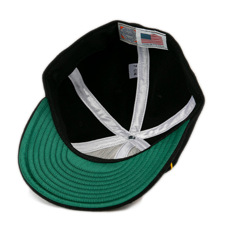 The inside of this EFF Oakland Caskets Co. 1938 Vintage Ballcap features a green underbrim, white lining, and an American flag tag marked “Made in U.S.A.” with size “7 1/4”—a timeless classic.