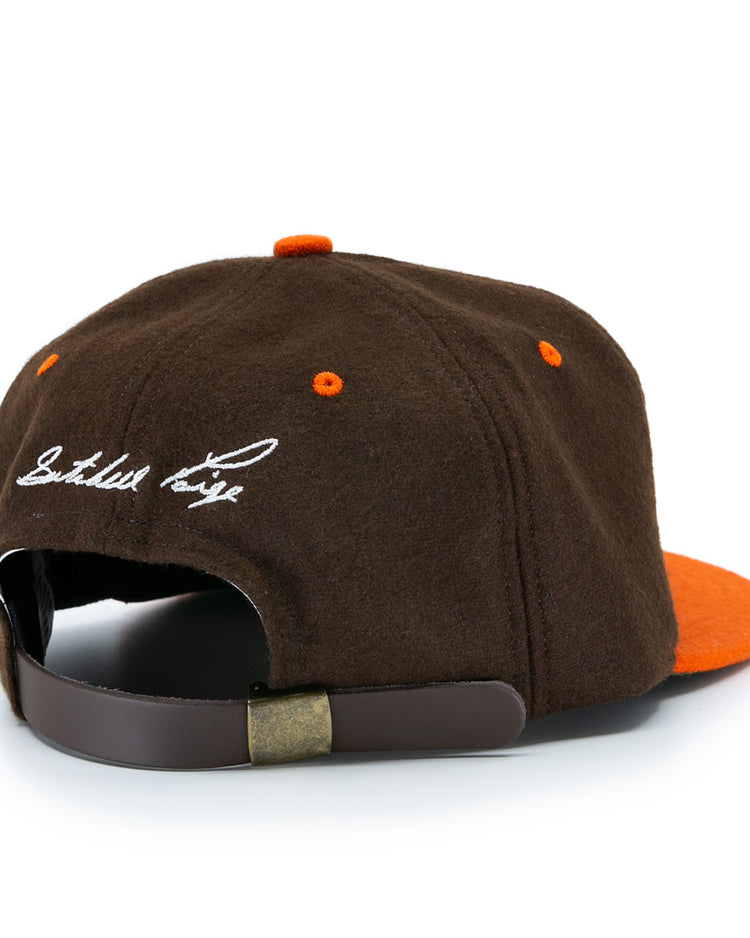 The Satchel Paige 1952 Signature Series Ballcap by Ebbets Field Flannels is a brown and orange vintage wool cap with a brown adjustable strap, metal clasp, and white embroidered script on the back—a classic nod to the Negro Leagues.