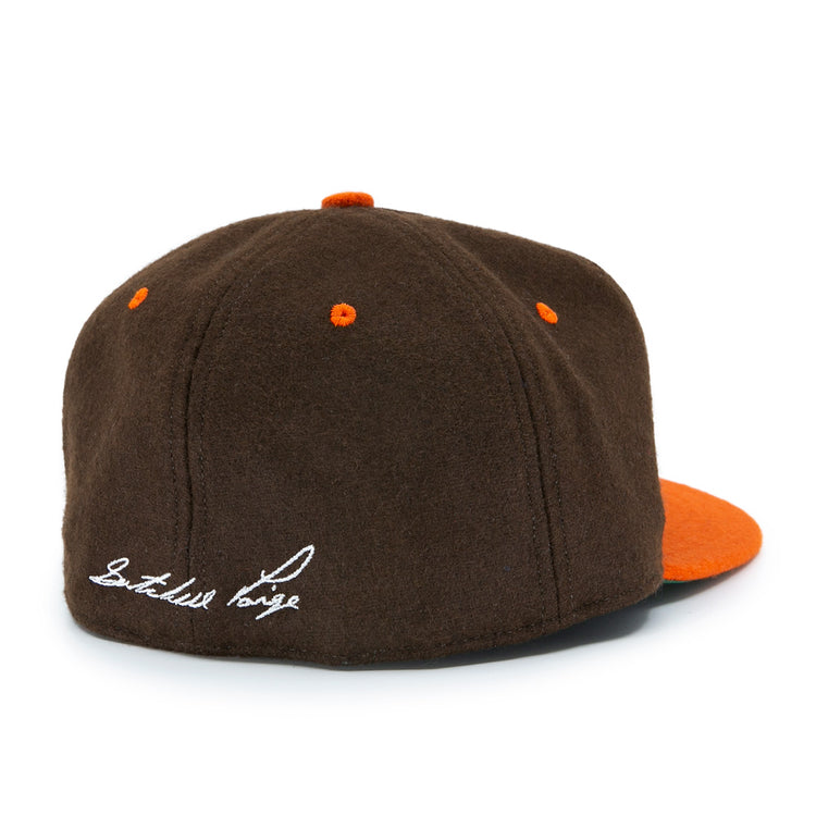 The Satchel Paige 1952 Signature Series Ballcap by Ebbets Field Flannels features brown vintage wool, orange accents, a flat orange brim, and white cursive embroidery on the back honoring Satchel Paige and the Negro Leagues.