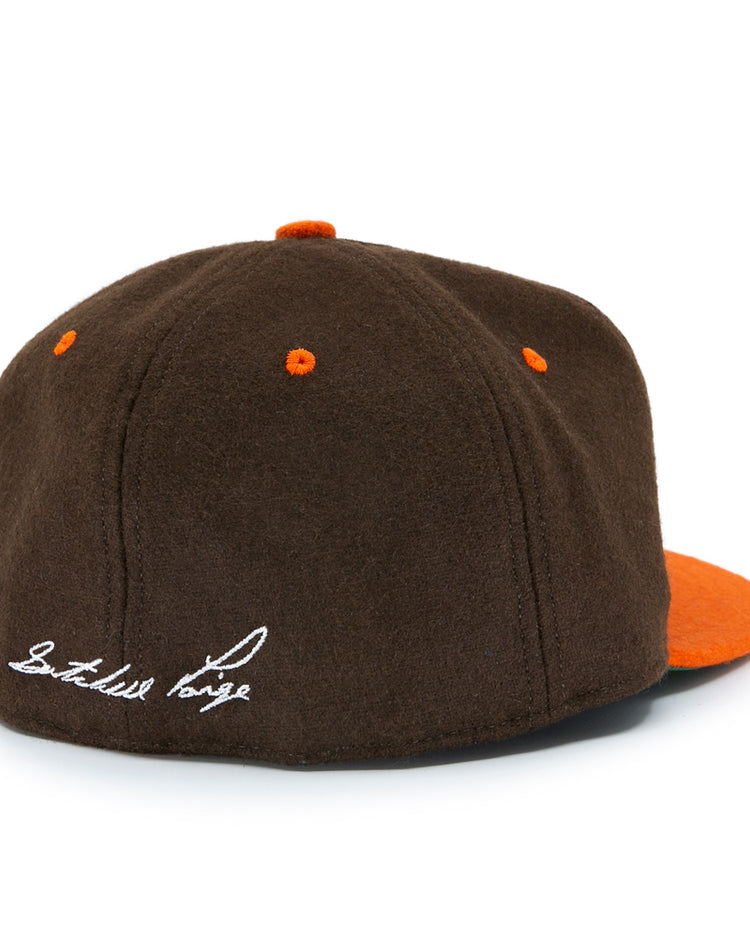 The Satchel Paige 1952 Signature Series Ballcap by Ebbets Field Flannels features brown vintage wool, orange accents, a flat orange brim, and white cursive embroidery on the back honoring Satchel Paige and the Negro Leagues.