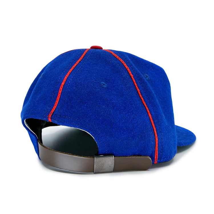 The EFF Phoenix Senators 1930 Vintage Ballcap is a blue wool cap with red seam stitching, featuring an adjustable brown strap and metallic clasp, inspired by the classic Arizona State League team.