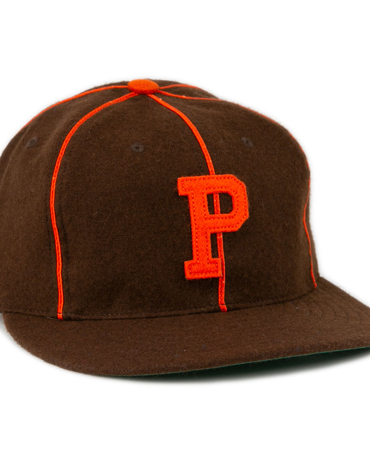 The EFF Pocatello Bannocks 1952 Vintage Ballcap is a brown wool baseball hat with orange piping, an orange top button, and a large orange “P” embroidered on the front.