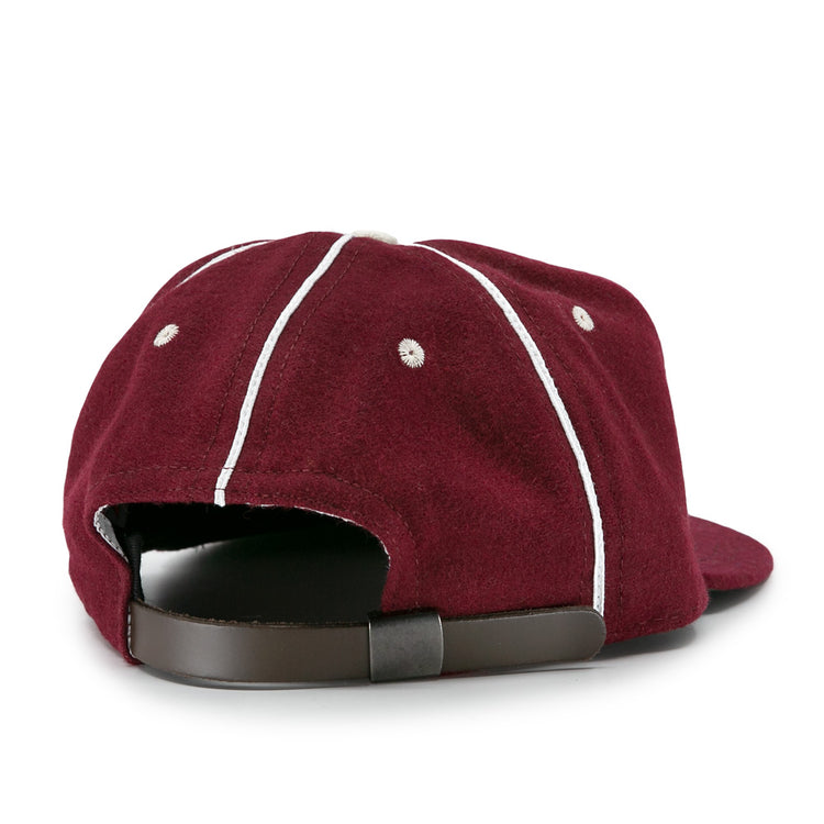 The EFF Quebec Athletics 1941 Vintage Ballcap is a maroon wool cap with white seams, ventilation holes, and an adjustable brown leather strap with metal buckle, seen from the back.