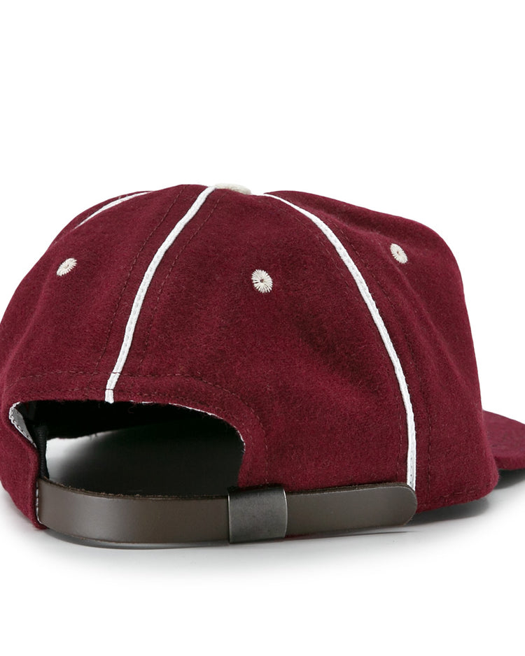 The EFF Quebec Athletics 1941 Vintage Ballcap is a maroon wool cap with white seams, ventilation holes, and an adjustable brown leather strap with metal buckle, seen from the back.