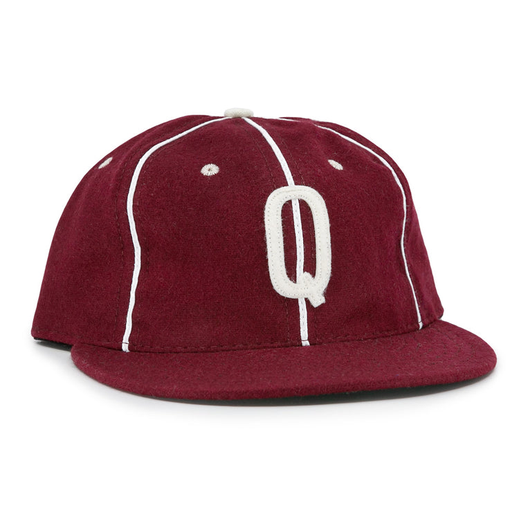 The EFF Quebec Athletics 1941 Vintage Ballcap is crafted from genuine wool in maroon with white piping, a flat brim, a classic top button, and features a bold white letter Q embroidered on the front.