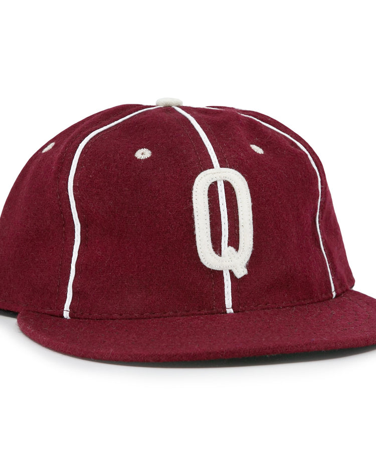 The EFF Quebec Athletics 1941 Vintage Ballcap is crafted from genuine wool in maroon with white piping, a flat brim, a classic top button, and features a bold white letter Q embroidered on the front.