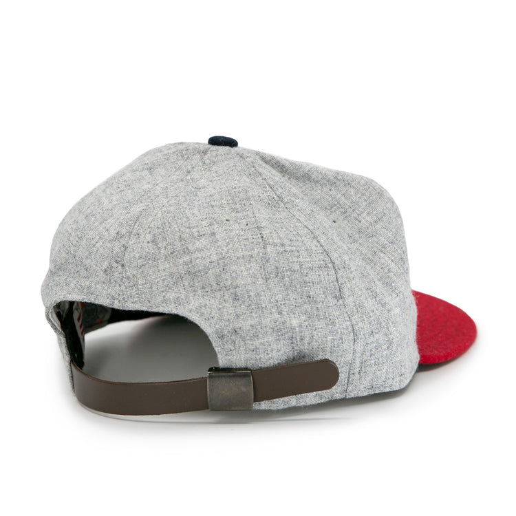 The Ebbets Field Flannels Regina Nationals 1933 Vintage Ballcap has a light gray crown, red brim, and adjustable dark brown strap with metal clasp. Inspired by classic ballcaps, its shown from the back against a white background.