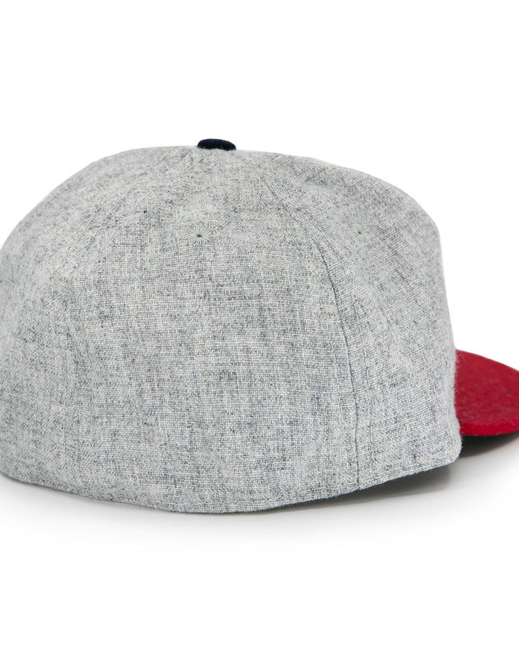 The Regina Nationals 1933 Vintage Ballcap by Ebbets Field Flannels is shown from the back, featuring a gray body, red brim, visible seam details, and a classic vintage design.