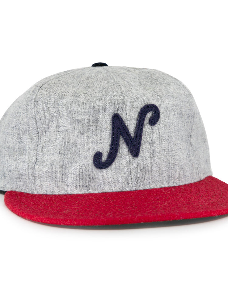 The Regina Nationals 1933 Vintage Ballcap by Ebbets Field Flannels is made from authentic wool, with a gray crown, red brim, and a dark blue cursive N on the front—faithfully recreating the original 1933 design.