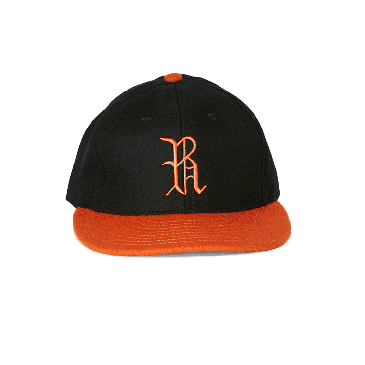 The EFF Richmond Virginians 1955 Vintage Ballcap is a black wool cap with an orange brim and top button, featuring a bold orange R on the front, inspired by the classic Richmond Virginians style.