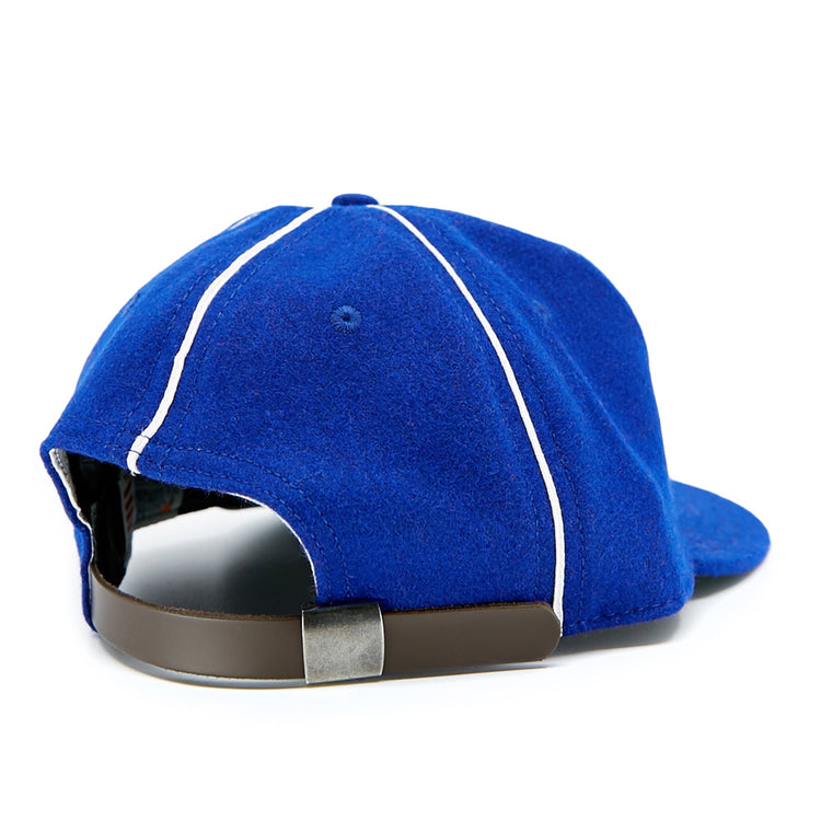 The Seattle Rainiers 1941 Vintage Ballcap by EFF features royal blue wool, white piping, metal eyelets, a brown leather adjustable strap with metal buckle, and a slightly curved brim—all viewed from the back.