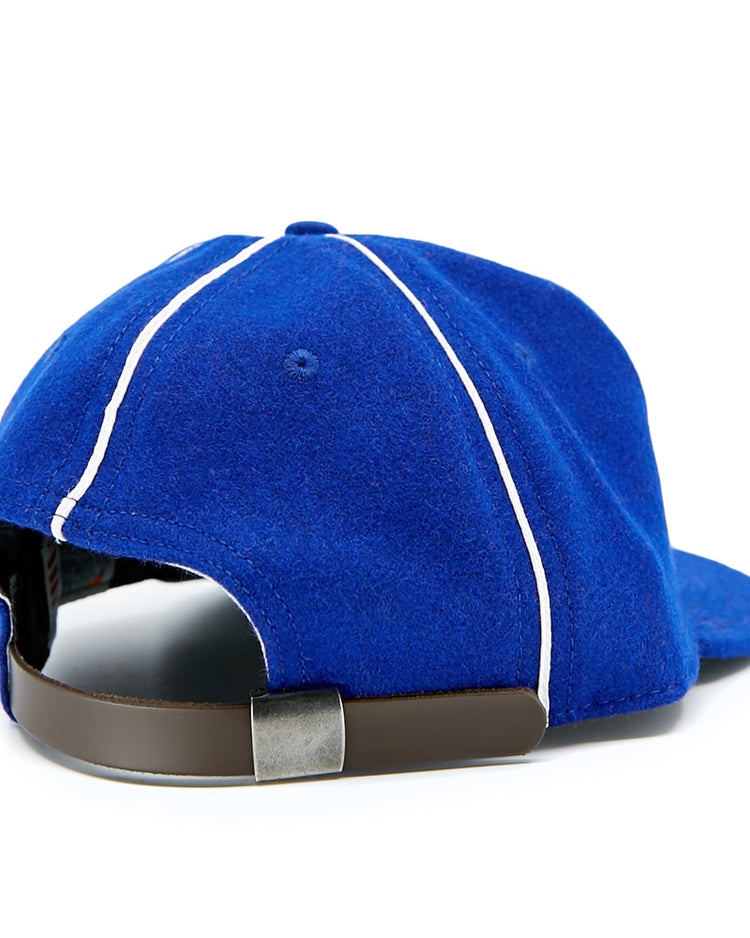 The Seattle Rainiers 1941 Vintage Ballcap by EFF features royal blue wool, white piping, metal eyelets, a brown leather adjustable strap with metal buckle, and a slightly curved brim—all viewed from the back.