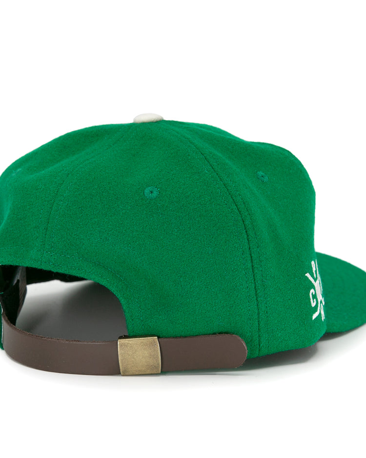 The EFF Seattle Metropolitans 1917 Vintage Ballcap is a green hat viewed from the back, showing an adjustable brown leather strap with brass buckle and a partially visible white embroidered side design.