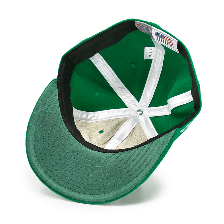 The image shows the inside of an EFF Seattle Metropolitans 1917 Vintage Ballcap in green, highlighting white stitching, inner panels, a size 7 1/4 tag with an American flag label, and a green underside brim.