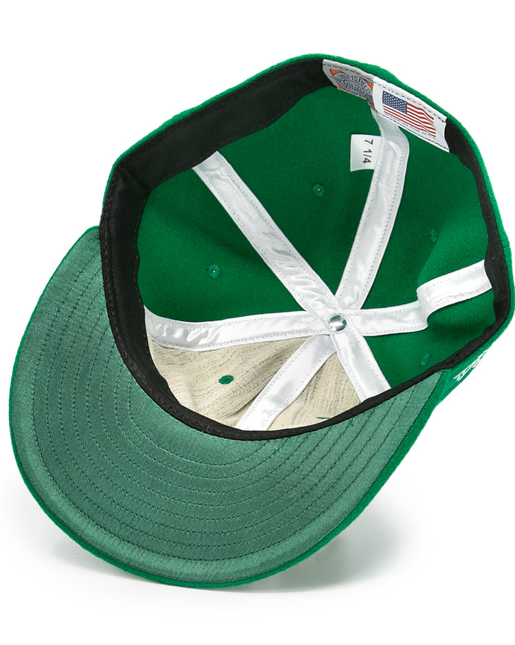 The image shows the inside of an EFF Seattle Metropolitans 1917 Vintage Ballcap in green, highlighting white stitching, inner panels, a size 7 1/4 tag with an American flag label, and a green underside brim.