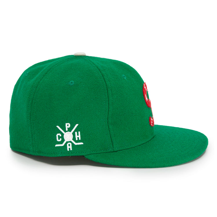 The EFF Seattle Metropolitans 1917 Vintage Ballcap is a green cap with a flat brim and a white embroidered side logo featuring C P H around a bat and ball, inspired by classic hockey hats. The front of the cap is partially visible.