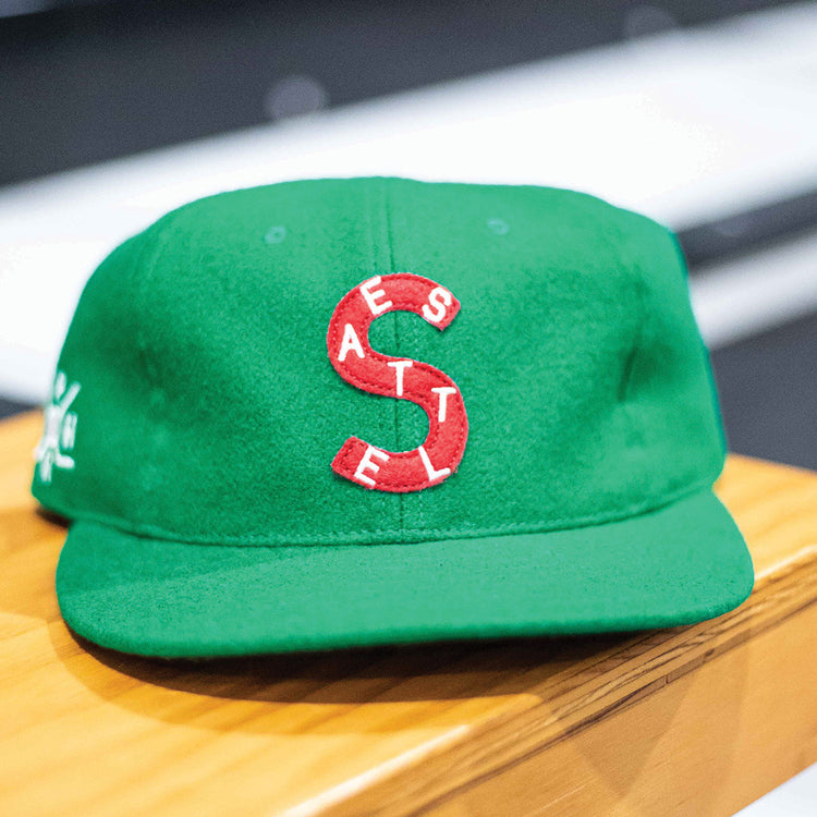 The EFF Seattle Metropolitans 1917 Vintage Ballcap is a green wool hat with a large red S and white SEATTLE lettering, featuring stitch details. This classic hockey cap recalls the Pacific Coast Hockey Association’s legacy.