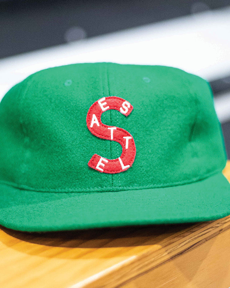 The EFF Seattle Metropolitans 1917 Vintage Ballcap is a green wool hat with a large red S and white SEATTLE lettering, featuring stitch details. This classic hockey cap recalls the Pacific Coast Hockey Association’s legacy.