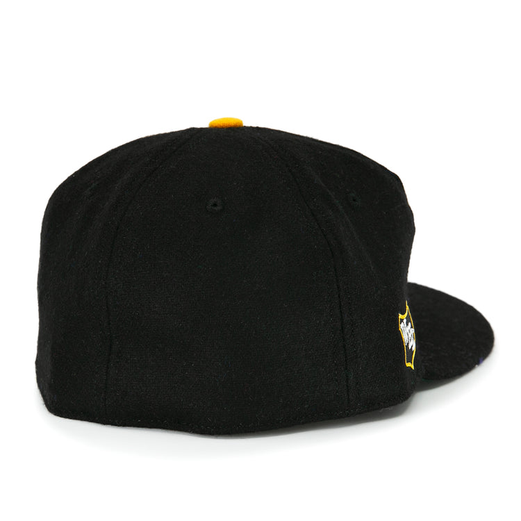 The EFF San Francisco Seals 1963 Vintage Ballcap is a black wool cap seen from the back, with a yellow top button and a yellow and white embroidered Seals logo near the closure.