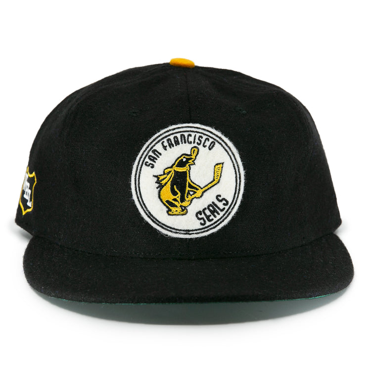 The EFF San Francisco Seals 1963 Vintage Ballcap is a wool cap with a round front patch showing a seal with a hockey stick and “San Francisco Seals,” plus a small left-side patch honoring the team’s Western Hockey League history.