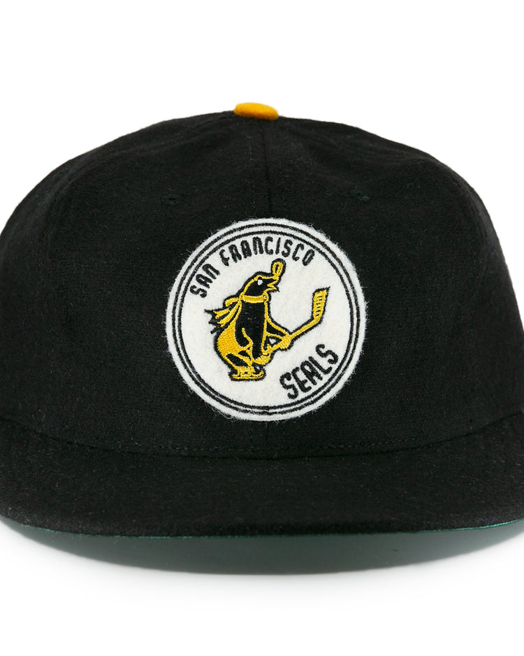 The EFF San Francisco Seals 1963 Vintage Ballcap is a wool cap with a round front patch showing a seal with a hockey stick and “San Francisco Seals,” plus a small left-side patch honoring the team’s Western Hockey League history.