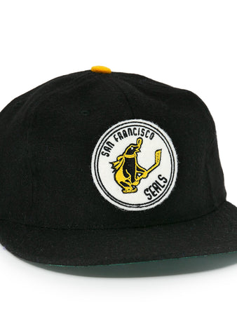 The EFF San Francisco Seals 1963 Vintage Ballcap features a hockey-playing seal logo on the front, an NHL shield patch, a flat brim, and yellow button—honoring the team’s Western Hockey League heritage.
