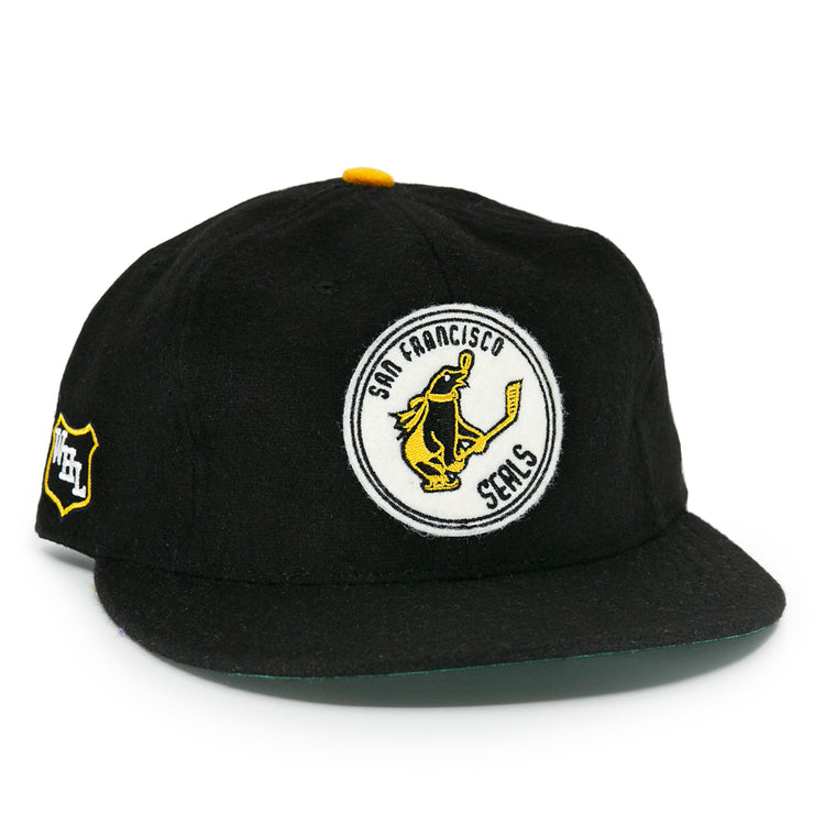 The EFF San Francisco Seals 1963 Vintage Ballcap features a hockey-playing seal logo on the front, an NHL shield patch, a flat brim, and yellow button—honoring the team’s Western Hockey League heritage.