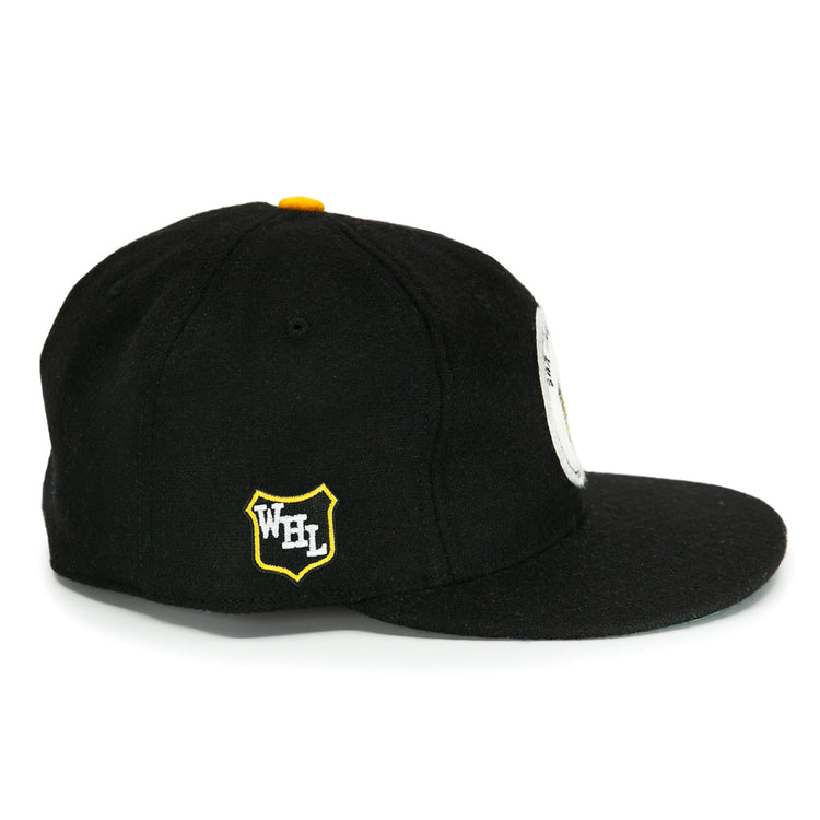 The EFF San Francisco Seals 1963 Vintage Ballcap is a black wool cap with a flat brim, yellow top button, yellow and white Western Hockey League shield logo on the side, and a partial round white patch on the front.