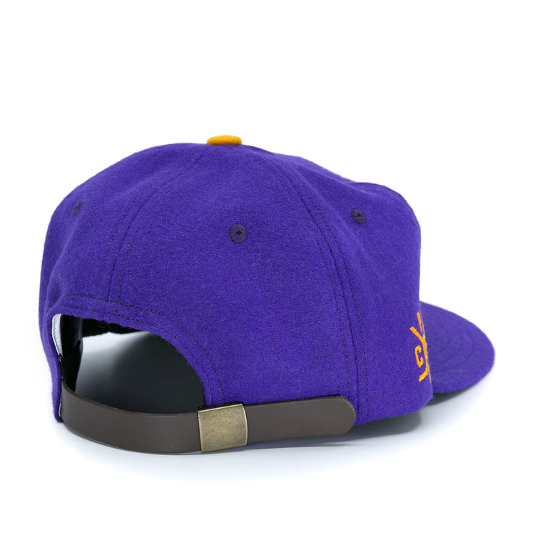 The EFF Spokane Canaries 1917 Vintage Ballcap is a purple wool cap with a brown adjustable leather strap, brass buckle, and a small yellow embroidered front design inspired by classic Pacific Coast Hockey Association style.