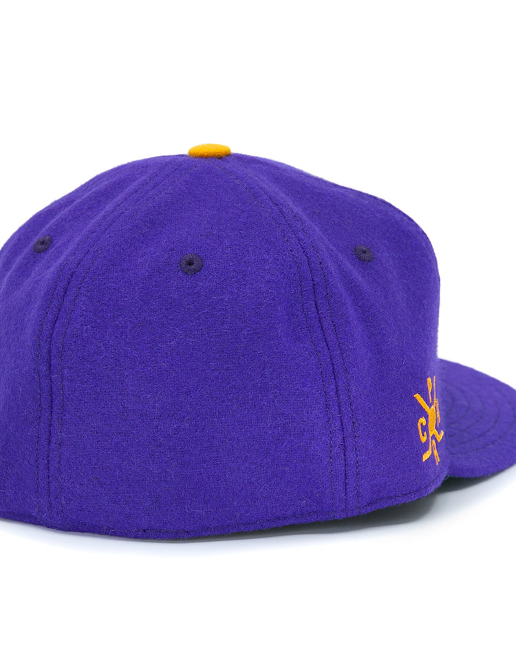 The EFF Spokane Canaries 1917 Vintage Ballcap is a purple wool cap with dark purple stitched eyelets and panels, a yellow top button, partial yellow side embroidery, and an adjustable leather strap for the perfect fit.