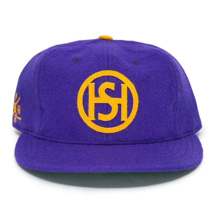 The EFF Spokane Canaries 1917 Vintage Ballcap features purple wool, a yellow circular HS logo, flat brim, small yellow button, and an adjustable leather strap—capturing classic Pacific Coast Hockey Association style.