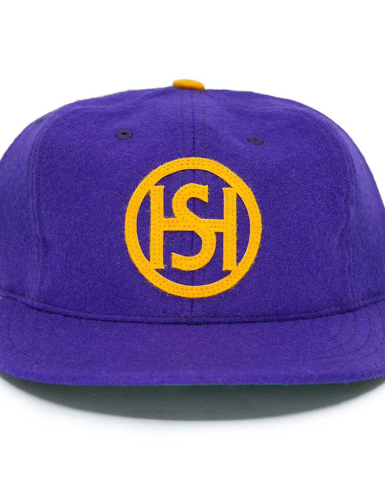 The EFF Spokane Canaries 1917 Vintage Ballcap features purple wool, a yellow circular HS logo, flat brim, small yellow button, and an adjustable leather strap—capturing classic Pacific Coast Hockey Association style.