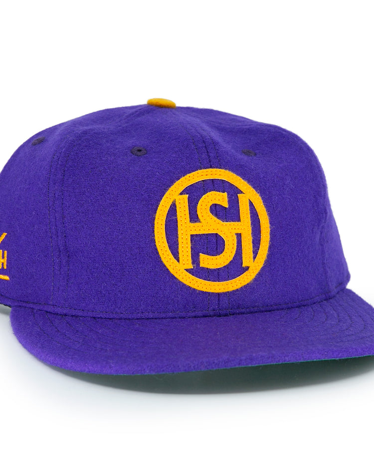The EFF Spokane Canaries 1917 Vintage Ballcap is a purple wool cap with a yellow embroidered circular ISH logo, Pacific Coast Hockey Association-inspired yellow side lettering, and an adjustable leather strap for comfort.