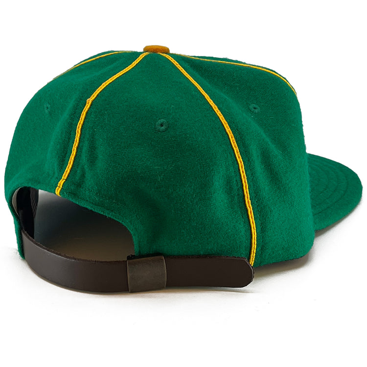 The EFF St. Patrick Shamrocks 1925 Vintage Ballcap is a green wool baseball cap with yellow piping, shown from the back. It features a brown adjustable strap with a metal buckle, inspired by the classic ballcap design.