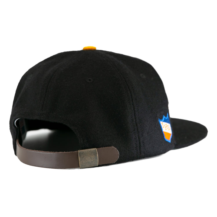 The EFF St. Paul Fighting Saints 1961 Vintage Ballcap in black features a brown adjustable strap with metallic clasp, a side patch, and classic wool cap style—a tribute to vintage Saints hockey team caps.