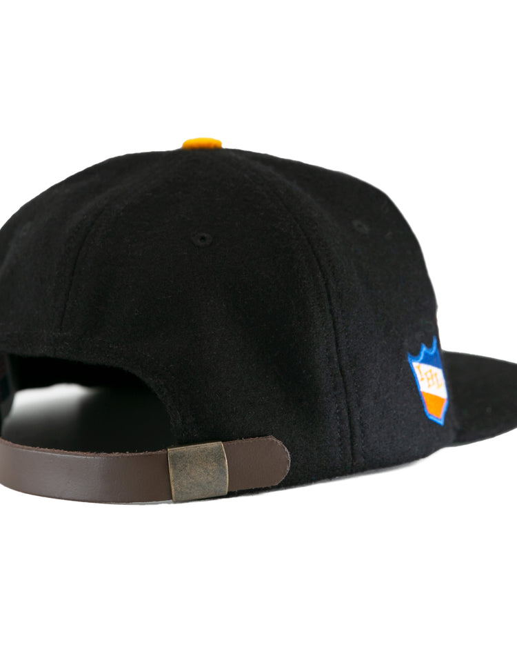 The EFF St. Paul Fighting Saints 1961 Vintage Ballcap in black features a brown adjustable strap with metallic clasp, a side patch, and classic wool cap style—a tribute to vintage Saints hockey team caps.
