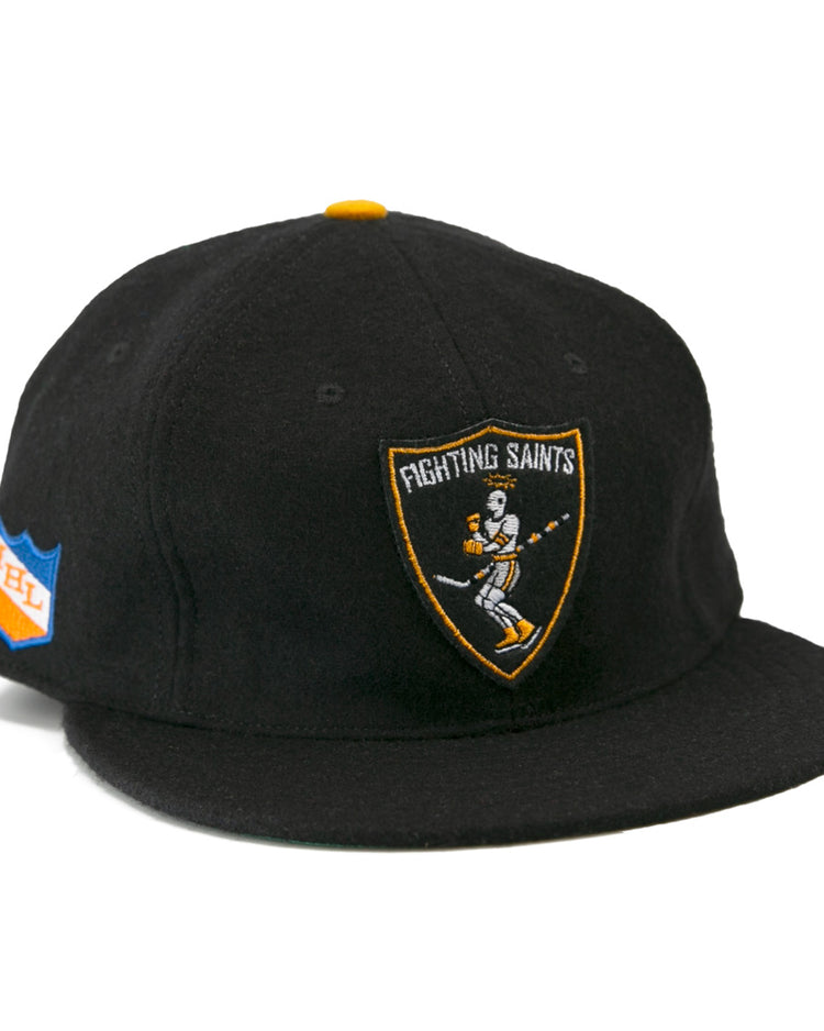 The EFF St. Paul Fighting Saints 1961 Vintage Ballcap is a black cap featuring a skeleton-hockey-stick Fighting Saints logo on the front and a blue/orange shield patch on the side—ideal for any Saints hockey fan.
