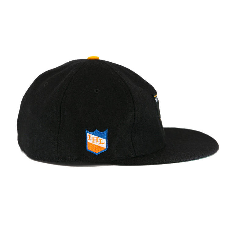 The EFF St. Paul Fighting Saints 1961 Vintage Ballcap is a black wool cap with a flat brim, yellow top button, and a blue and orange shield patch on the side featuring IHL in white.
