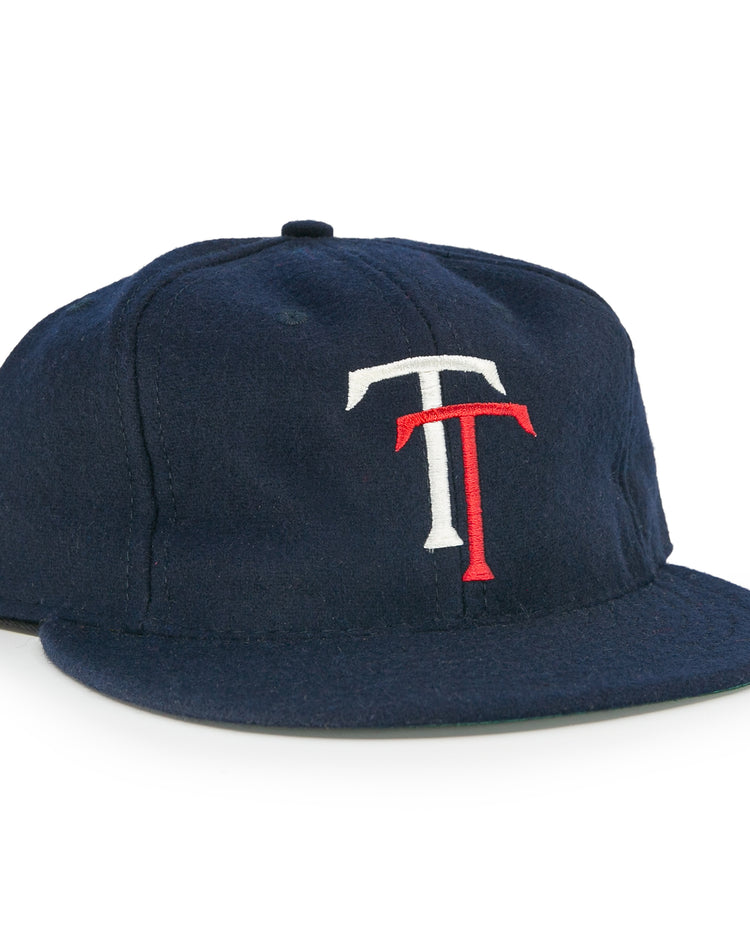 The EFF Tacoma Twins 1974 Vintage Ballcap is a navy blue cap featuring a white and red interlocking T logo on the front, inspired by the Pacific Coast League.