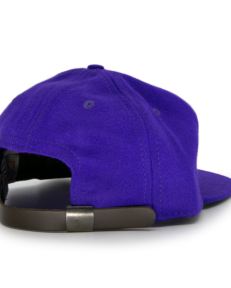 The Club Teléfonos 1943 Vintage Ballcap by Ebbets Field Flannels is a purple wool hat shown from the back, featuring a black adjustable strap with a metal buckle.