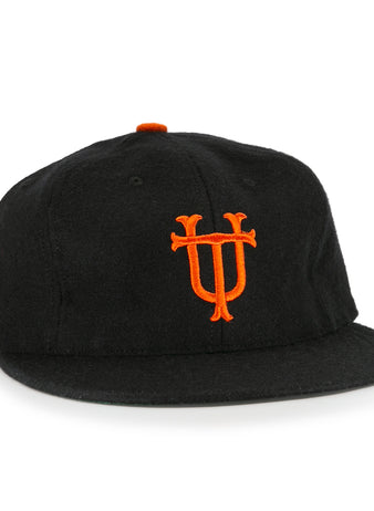 The University of Tennessee 1951 Vintage Ballcap by Ebbets Field Flannels is a black cap with a flat brim, orange top button, and an ornate orange U and T embroidered on the front in classic UT style.