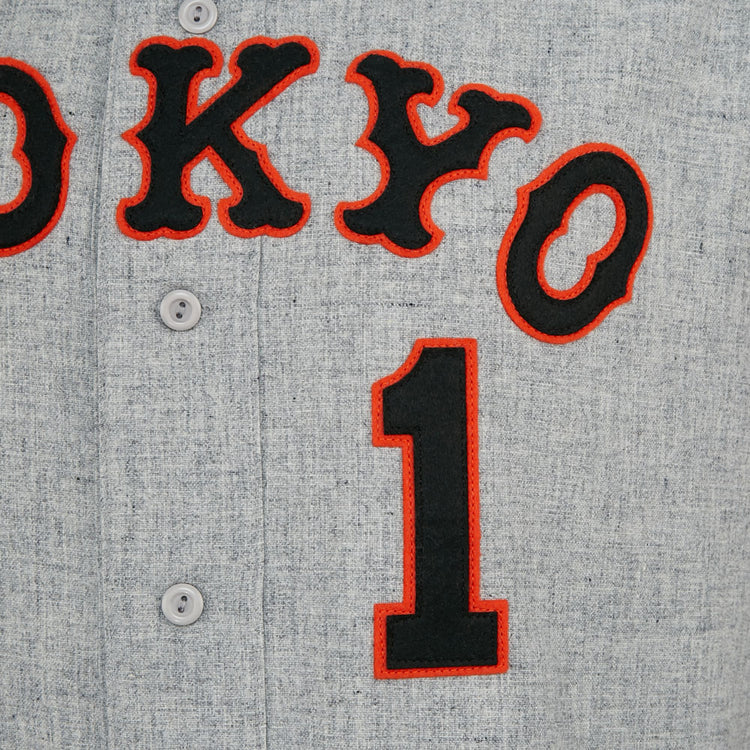 A close-up of the EFF Tokyo Kyojin (Giants) 1961 Road Jerseys gray fabric shows black and red TOKYO lettering, a large black number 1 below, and three buttons, capturing details of this classic Japanese League replica.