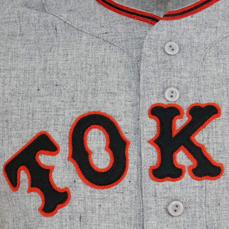 Close-up of the EFF Tokyo Kyojin (Giants) 1961 Road Jersey: light gray with bold black letters outlined in red spelling TOK, white buttons, and red collar trim—an authentic Japanese League classic.