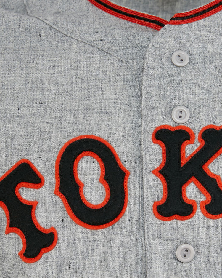 Close-up of the EFF Tokyo Kyojin (Giants) 1961 Road Jersey: light gray with bold black letters outlined in red spelling TOK, white buttons, and red collar trim—an authentic Japanese League classic.
